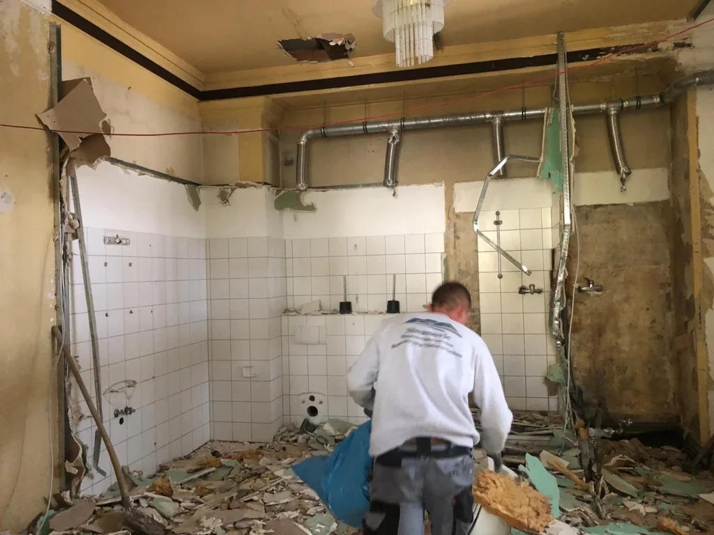 Handwerker beim Rückbau eines alten Badezimmers
