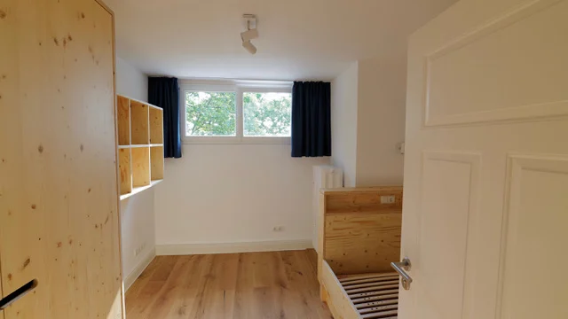 Renoviertes Kinderzimmer mit Holzmöbeln und Vollholzboden