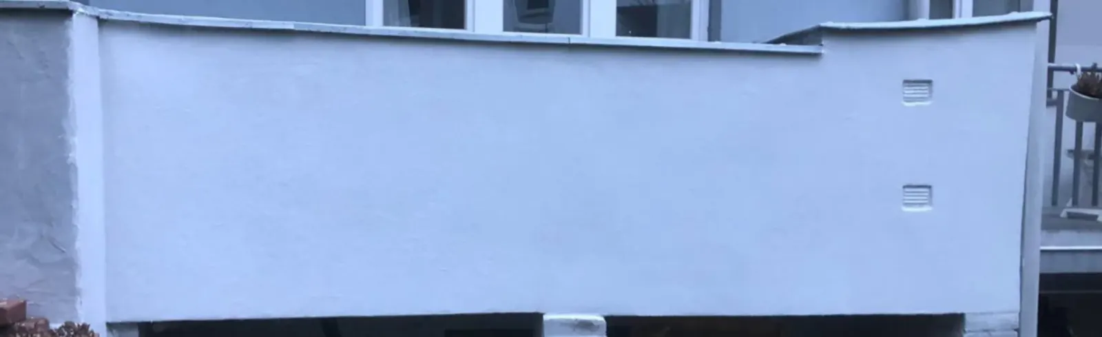 Nachher: Sanierter, frisch verputzter Fassadensockel